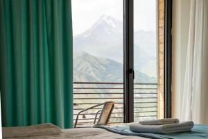 a bedroom with a bed and a view of a mountain at Kazbegi Hotel Grand View in Kazbegi