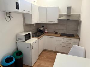 a small kitchen with white cabinets and a microwave at Residence Ai Melograni in Silea