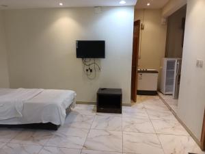 a bedroom with a bed and a tv on a wall at افاق in Khamis Mushayt