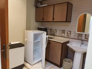 a small kitchen with a refrigerator and a sink at افاق in Khamis Mushayt