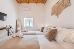 a white living room with a couch and a tv at Olea holiday house in Astérion +27 photos