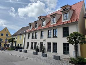 a white building with a red roof on a street at Parzivita Suites in Wolframs-Eschenbach
