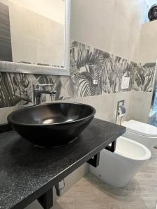 a bathroom with a black sink and a toilet at La Base Fitness House in Decimomannu