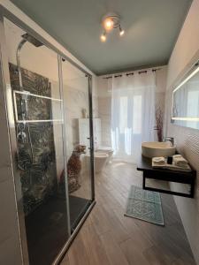 a bathroom with a shower and a tub and a sink at La Base Fitness House in Decimomannu