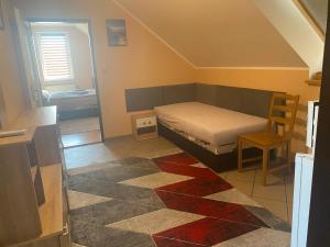 a small bedroom with a bed and a chair at Penzion Kolovna in Dobrá