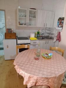 a kitchen with a table with a pink table cloth on it at Centar in Valjevo +3 photos