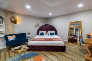 a bedroom with a large bed and a blue chair at VIBES! Free Parking, Piano, King Bed in Washington, D.C.