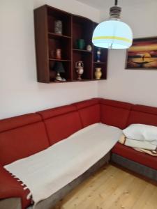 a red couch sitting in a room under a light at Centar in Valjevo