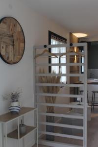 a white book shelf in a living room with a mirror at Le Cocon des Acacias in Tournon-sur-Rhône +15 photos