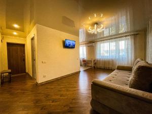 a living room with a couch and a television on the wall at Апартаменти ТЦ Галактика in Kremenchuk