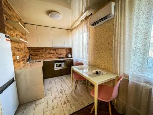 a small kitchen with a table and chairs and a refrigerator at Апартаменти ТЦ Галактика in Kremenchuk