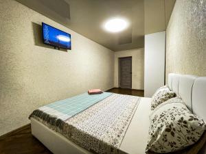 a bedroom with a bed with a tv on the wall at Апартаменти ТЦ Галактика in Kremenchuk