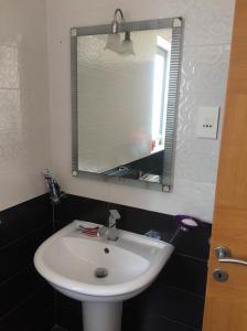 a bathroom with a white sink and a mirror at Quiet and Lovely Residence in St. Julianʼs