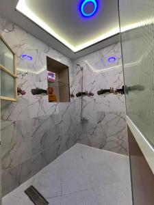 a bathroom with a shower with a marble wall at Bab Rmouz apartment in Tétouan +70 photos