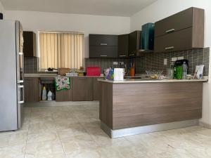 a kitchen with brown cabinets and a counter top at Quiet and Lovely Residence in St. Julianʼs