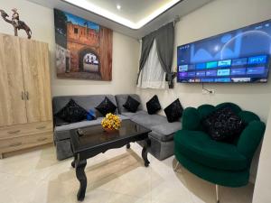 a living room with a couch and a table and a tv at Bab Rmouz apartment in Tétouan