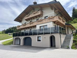 a building with a balcony on top of it at Peterlehen Appartements in Altenmarkt im Pongau