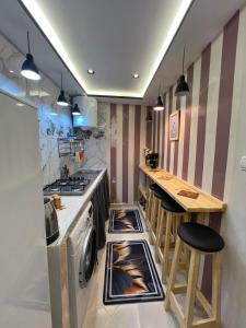 a kitchen with a stove and a counter with stools at Bab Rmouz apartment in Tétouan