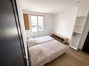 a small bedroom with two beds and a window at Le cocon Portelois in Le Portel