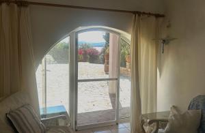 an open glass door to a patio with a view at Seafront House, Private Beach, Sunset View, Diliso in Vathírrevma