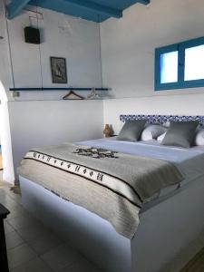 a bedroom with a large bed with white walls at El Baraka in Houmt Souk