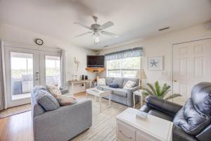 a living room with two couches and a ceiling fan at 7630 - Obx Box in Avon