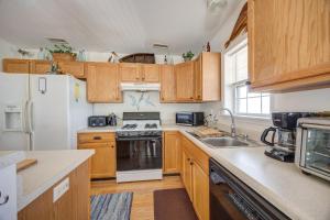 a kitchen with wooden cabinets and a white refrigerator at 7630 - Obx Box in Avon +21 photos