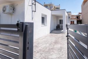 a gate to a white house with a balcony at Newly built detached house with parking 2 in Larisa