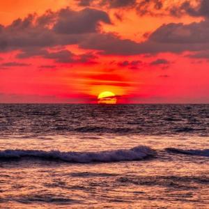 a sunset over the ocean with the sun at Le cocon Portelois in Le Portel