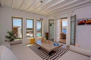a living room with white furniture and large windows at South Star private Villa in Mikonos