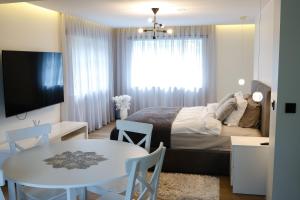 a bedroom with a bed and a table and a dining room at Lumy Housing in Pärnu