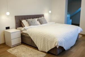 a bedroom with a large bed with a white bedspread and a rug at Lumy Housing in Pärnu
