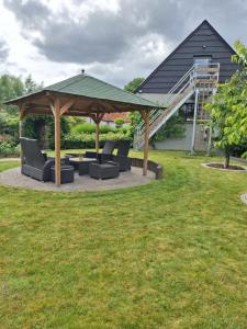 a gazebo with chairs and a table in a yard at Heuvelzicht in Wortegem