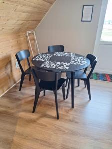 a black table with four chairs in a room at Heuvelzicht in Wortegem