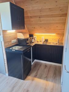 a small kitchen with black cabinets and a sink at Heuvelzicht in Wortegem