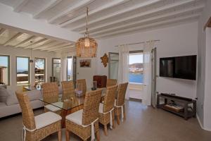 a dining room and living room with a table and chairs at South Star private Villa in Mikonos +22 photos
