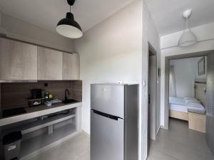 a kitchen with a refrigerator and a bedroom at Makis House in Nikiti