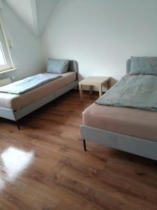 a bedroom with two beds and a table at Aparthotel Boardinghouse BRACK mit Parkplatz Küche WIFI in Bielefeld