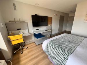 a bedroom with a bed and a flat screen tv at Micro Hotel in Conyers