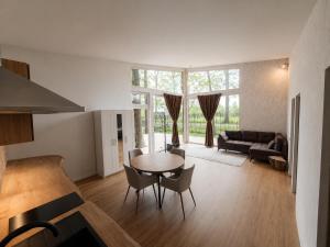 a kitchen and living room with a table and chairs at DEIVID house for rent in Skulte