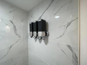 a bathroom with white marble walls and a soap dispenser at VIBES! Free Parking, Piano, King Bed in Washington, D.C. +7 photos
