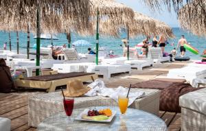 a table with a plate of food and drinks on a beach at Piatsa Michalis in Potos