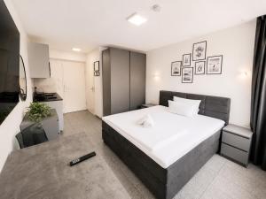a bedroom with a large bed and a kitchen at Lipp Apartments in Cologne +14 photos
