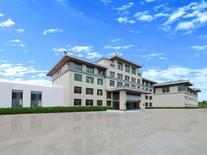 a large white building with a sky in the background at Mercure Beijing Universal Resort in Beijing