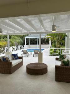 a covered patio with couches and a table and chairs at Casa Colibri in Saint James