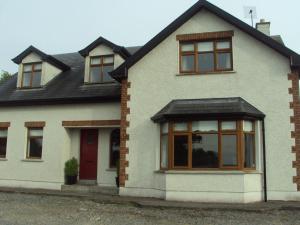 a white house with windows and a red door at Shannonside Studios in Athlone