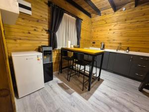 a kitchen with a counter and a table and a refrigerator at Yonga Bungalov in Akcaabat