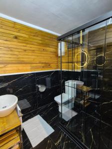 a bathroom with a glass shower and a toilet at Yonga Bungalov in Akcaabat