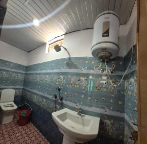 a bathroom with a sink and a toilet at Hotel astha in Phata