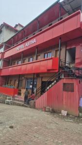 a red building with a hotel australia at Hotel astha in Phata